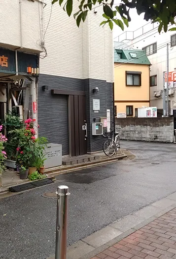 【3】トシユキの店を通過しすぐ左折直進すると、レンガ色の道に突き当たりますので、右手のビル２階にお店があります。