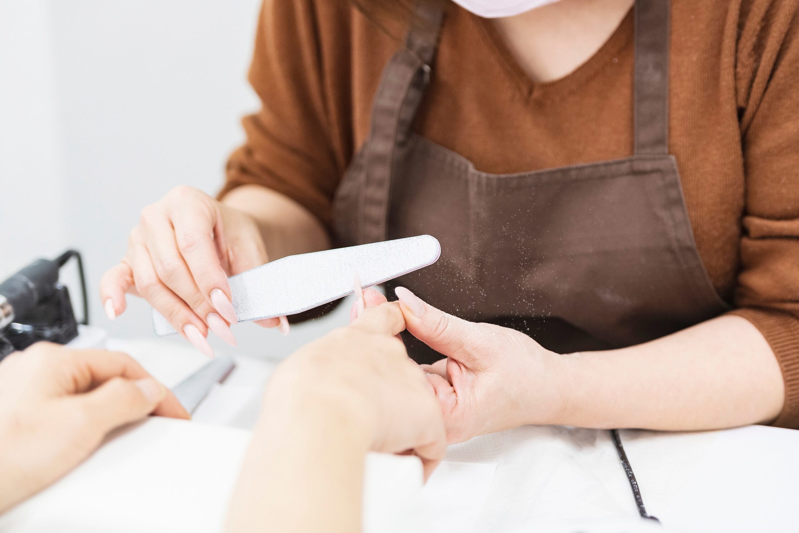 ネイルサロンでファイリングケアを受ける女性