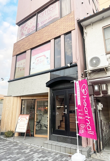 【3】大きな交差点の隅にあるピンク色の建物の3階に店舗があります。